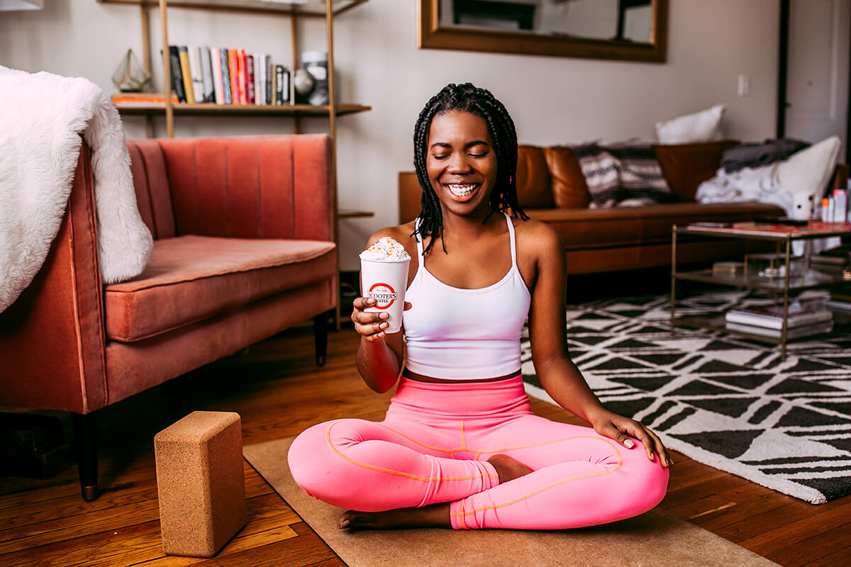 Woman in yoga pose holding coffee