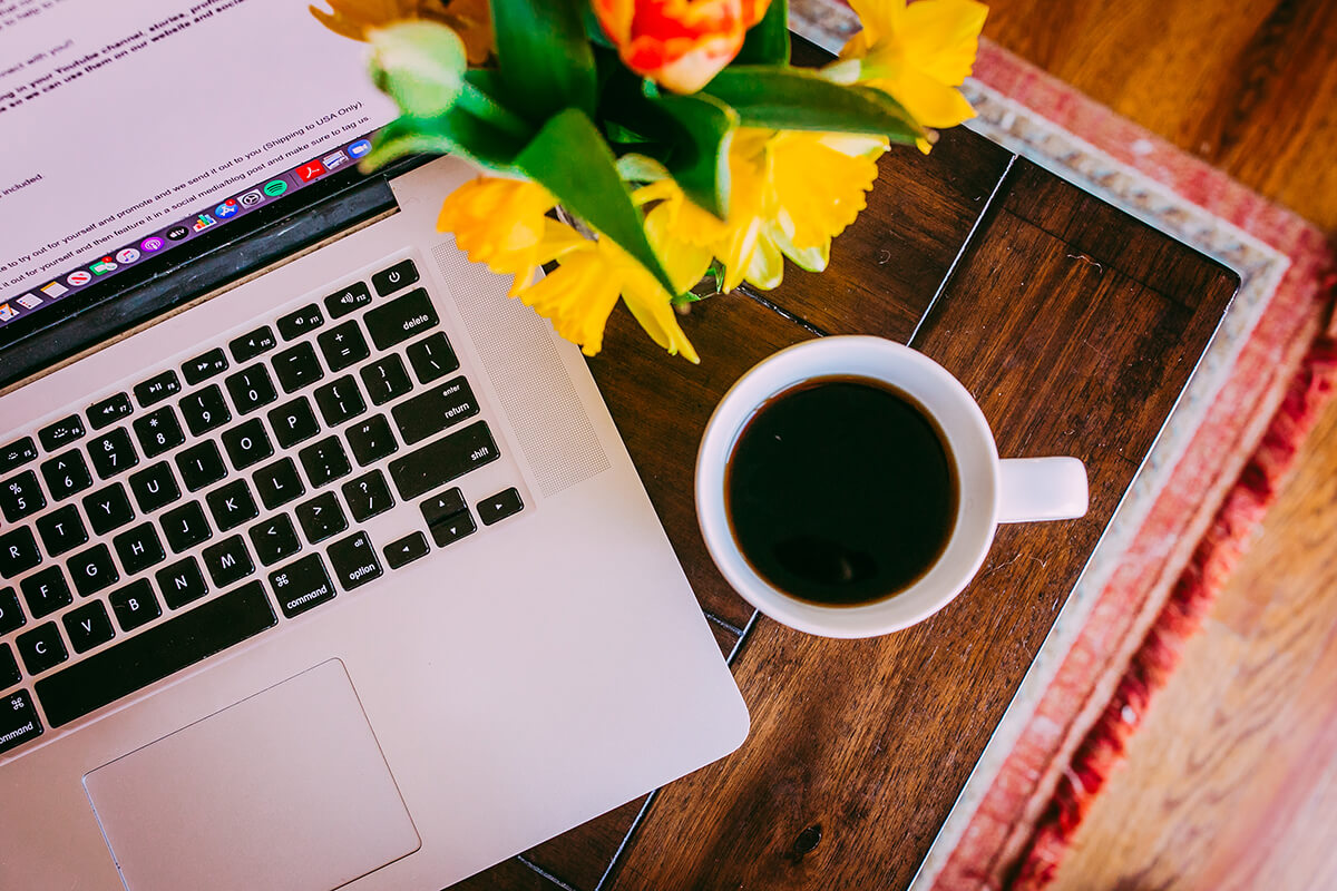 Overhead shot of coffee cup by computer