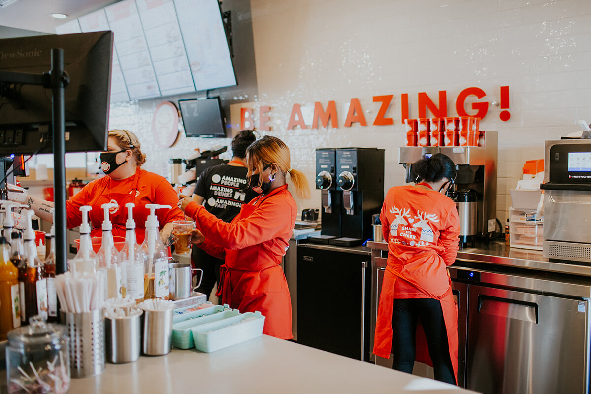 Four people working inside a coffee shop