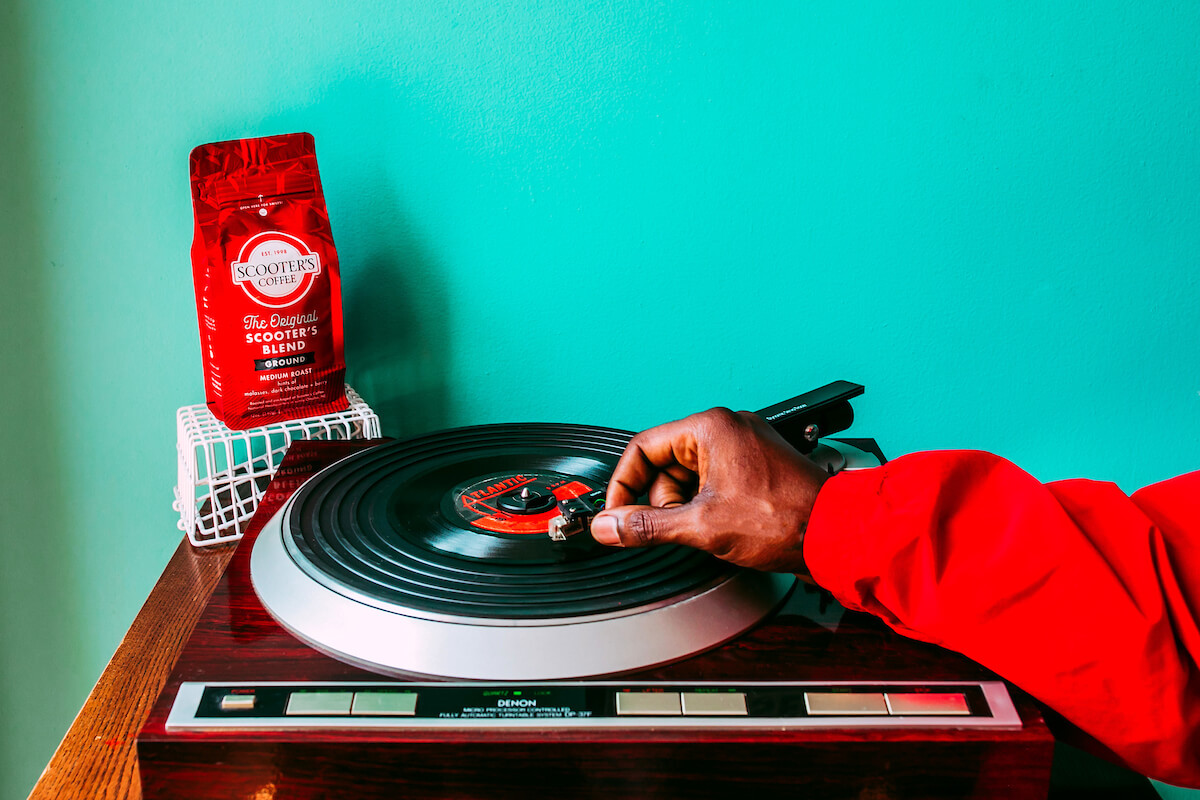 Hand on record player with coffee bag in background