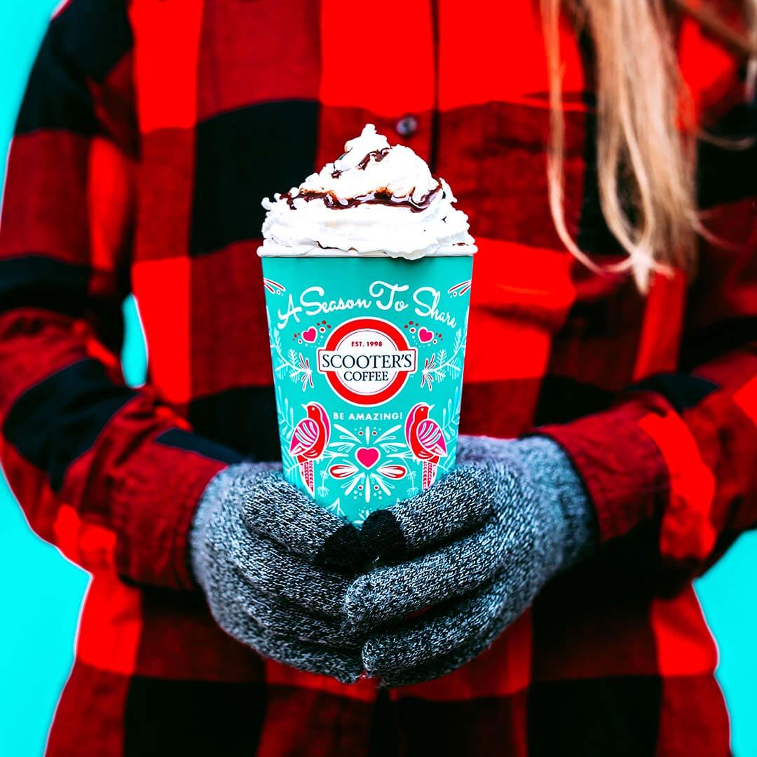 Woman in red plaid holding blue coffee cup