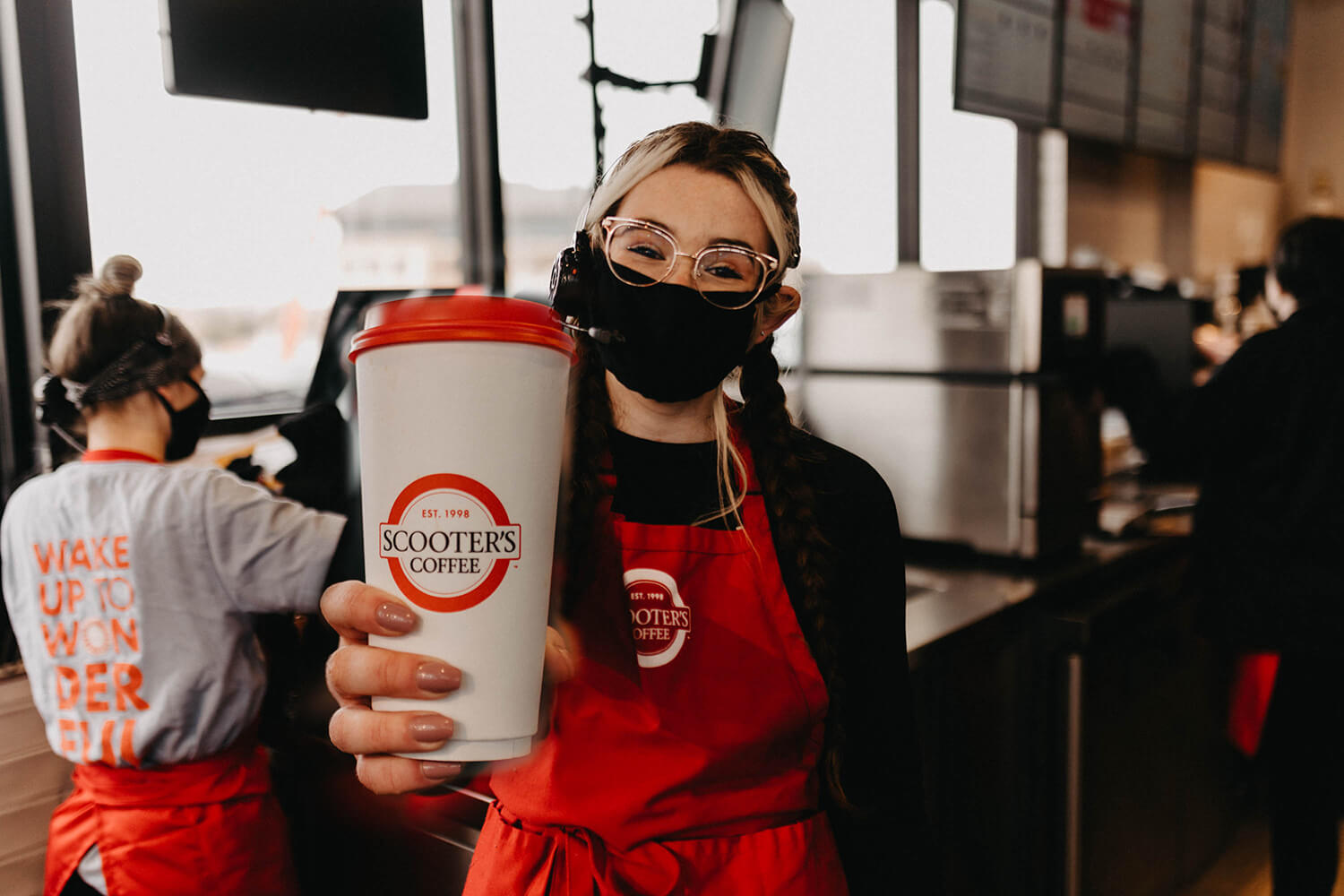 Barista holding out cup of coffee