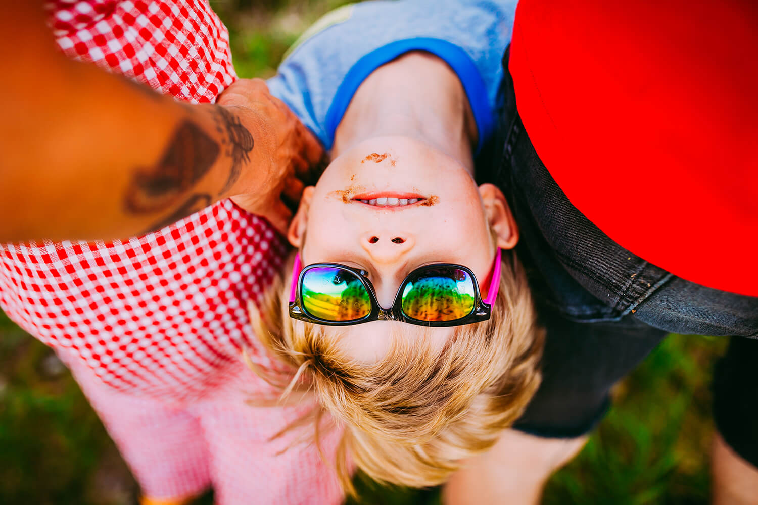 Boy in sunglasses looking at camera upside down