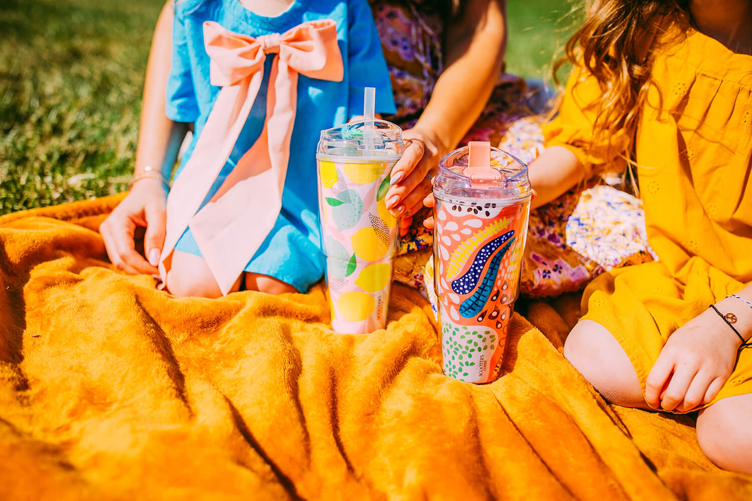 Two colorful cups on picnic blanket