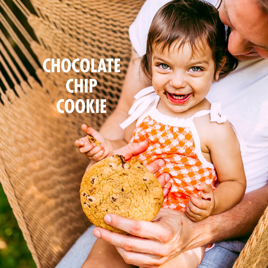 Girl with dad holding chocolate chip cookie