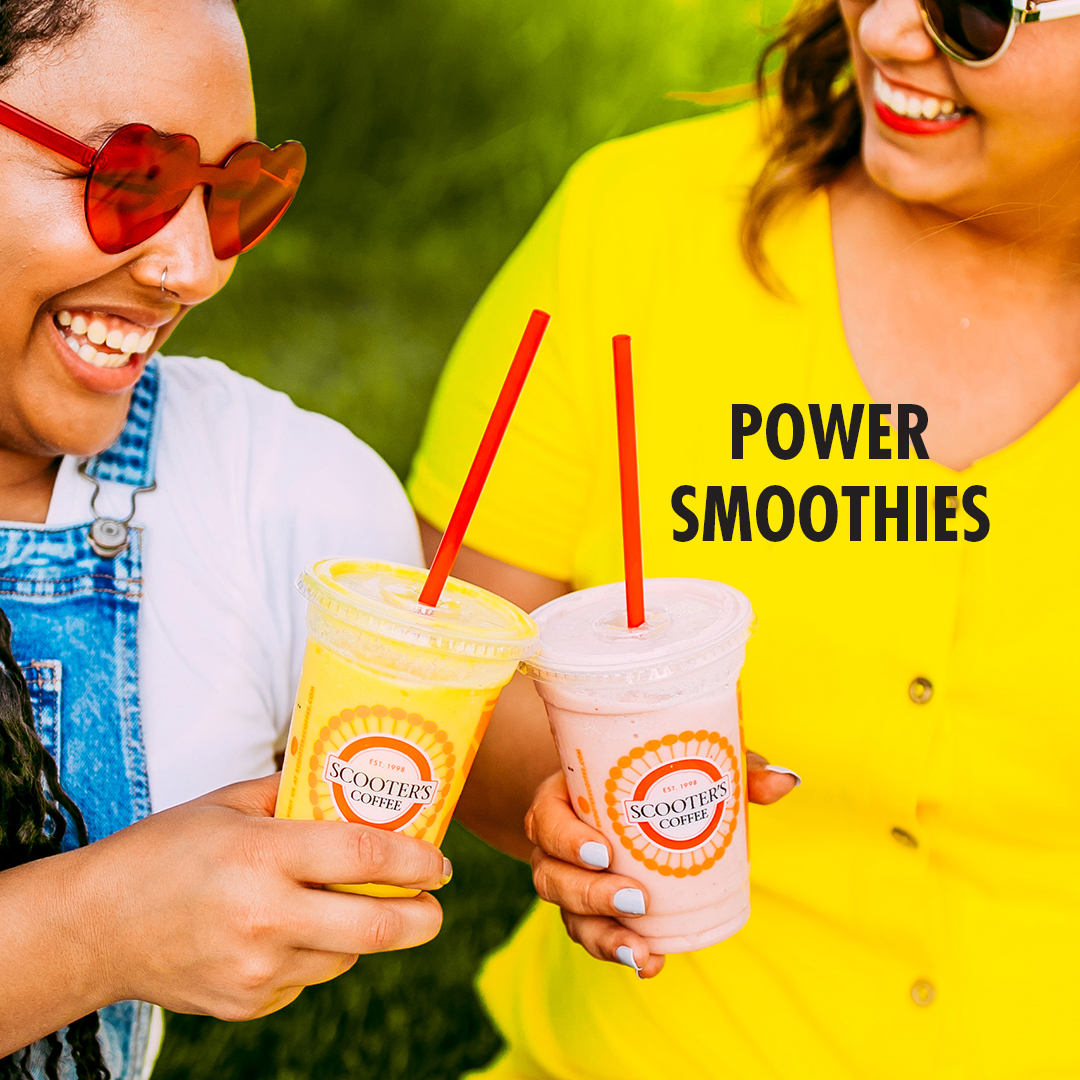 Two women cheers with smoothies