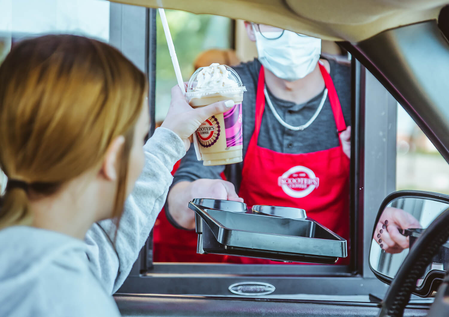 Customer receiving coffee in drive-thru