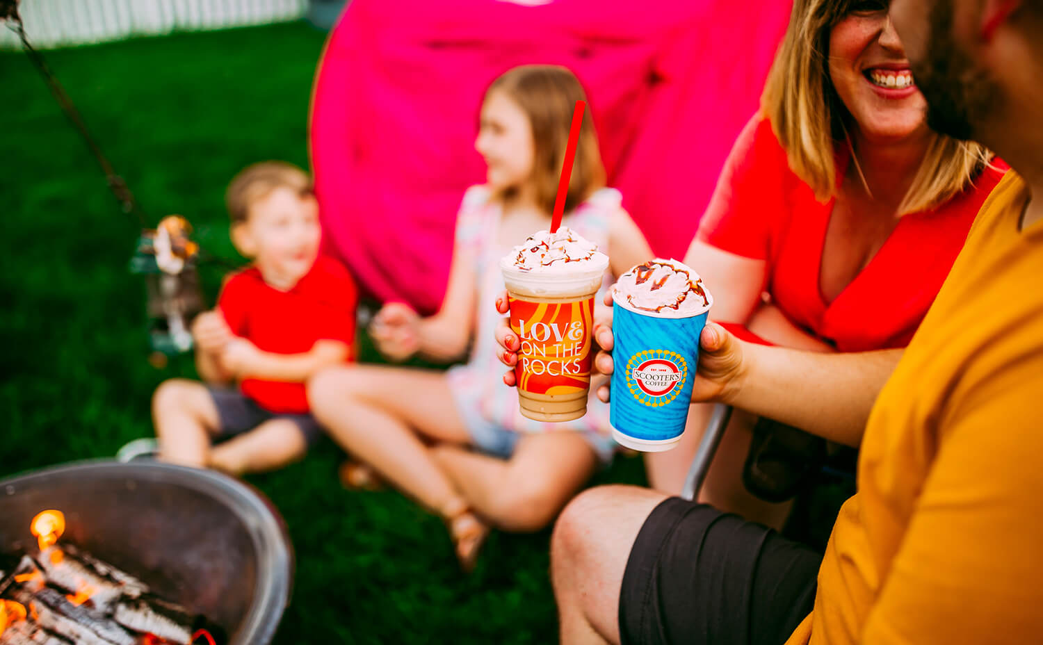 Family around campfire with coffee drinks